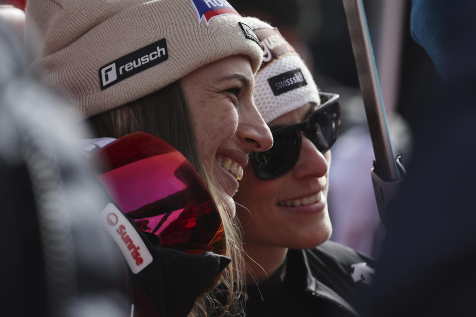 Switzerland's Jasmine Flury and Switzerland's Lara Gut Behrami wait at finish after completing an alpine ski, women's World Cup downhill race, in Crans Montana, Switzerland, Friday, Feb. 16, 2024. (AP Photo/Marco Trovati)