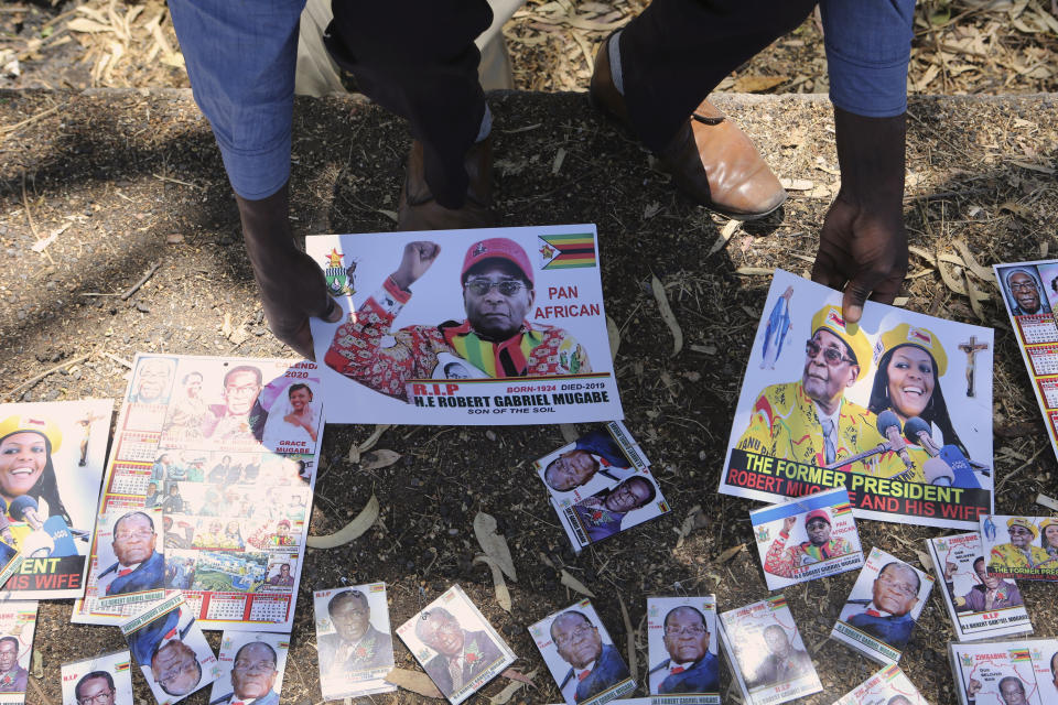 A vendor sells memorabilia outside former Zimbabwean President Robert Mugabe's rural home in Zvimba, about 100 kilometer north west of the capital Harare, Saturday, Sept. 28, 2019. According to a family spokesperson Mugabe is expected to be buried at the residence after weeks of drama mystery and contention over his burial place.(AP Photo/Tsvangirayi Mukwazhi)