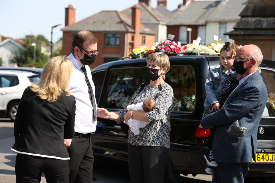 Husband Josh with his newborn daughter Eviegrace, being carried by a relative (name not known) after the coffin of Samantha Willis (nee Curran) from Strathfoyle is taken from St Columb's Church, Londonderry, following her funeral. The mother-of-four died with Covid-19 shortly after giving birth on Friday. Picture date: Monday August 23, 2021.