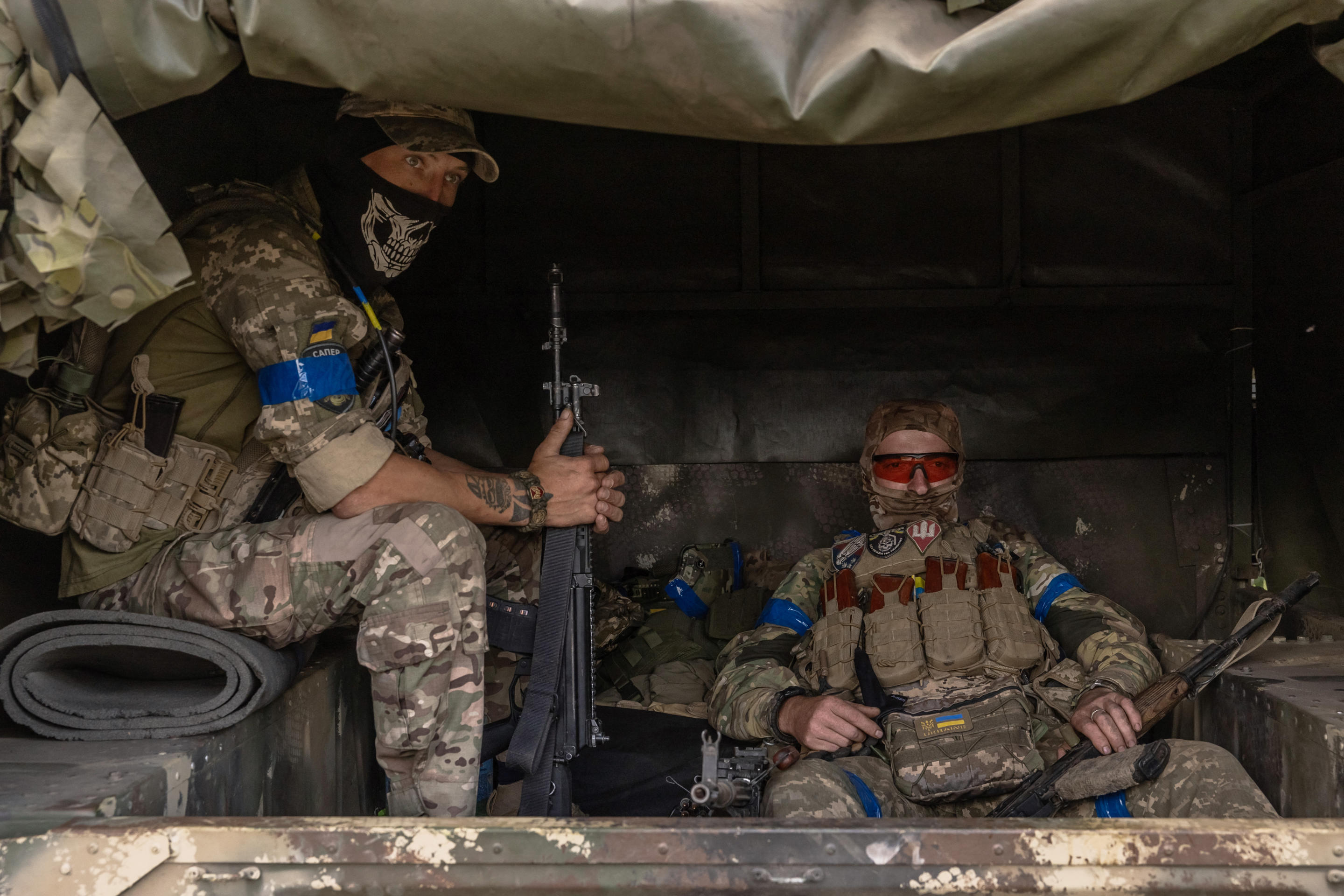 Ukrainian servicemen wait in a military vehicle to head for a combat mission.