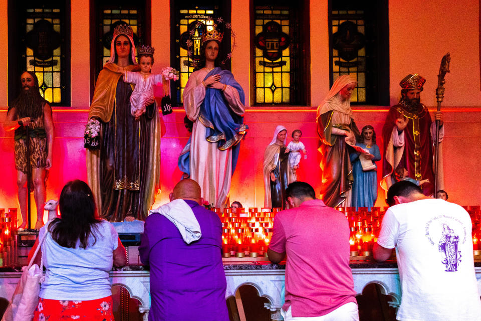 Parishioners pray to Our Lady of Mount Carmel, Sunday, July 17, 2022, after her return to the church in the Brooklyn borough of New York. The Giglio feast recreates the return of St. Paulinus, the Bishop of Nola, Italy. (AP Photo/Julia Nikhinson)