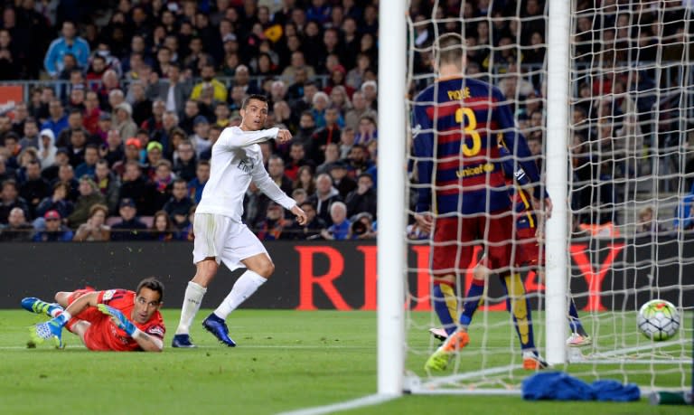 Real Madrid's Portuguese forward Cristiano Ronaldo (L) looks at the ball after scoring a goal during the Spanish league "Clasico" football match FC Barcelona vs Real Madrid CF at the Camp Nou stadium in Barcelona on April 2, 2016