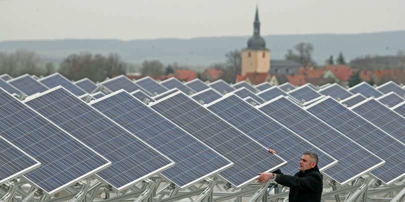 A man checks solar modules on a roof in Soemmerda, November 2008