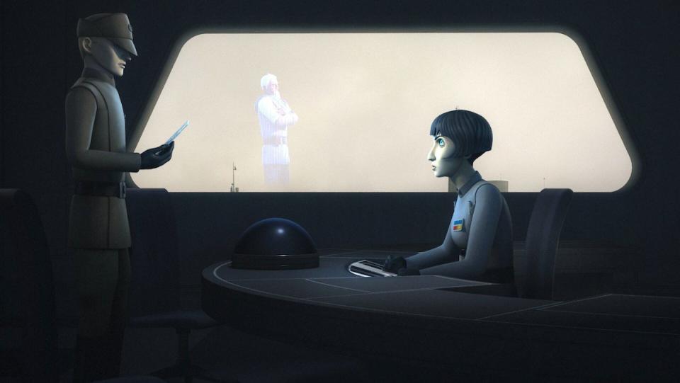 An Imperial officer looks at a hologram of a bearded man while another officer stands in front of her desk.