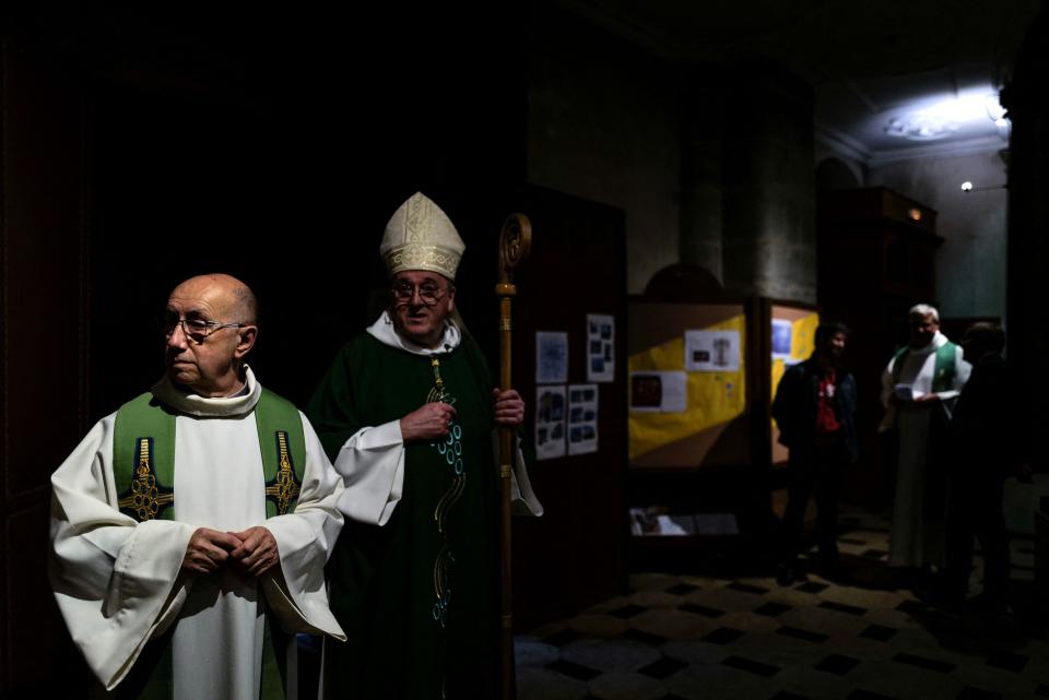 Father Didier Milani (L) speaks with Bishop Yves Le Saux (C) ahead of mass (AFP via Getty Images)