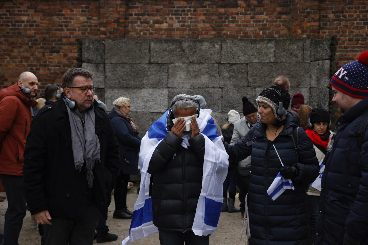 Zvika Karavany, 72, a Yemeni-born Israeli, wipes his tears in front of the Death Wall in the former Nazi German concentration and extermination camp Auschwitz during ceremonies marking the 78th anniversary of the liberation of the camp in Oswiecim, Poland, Friday, Jan. 27, 2023. (AP Photo/Michal Dyjuk)