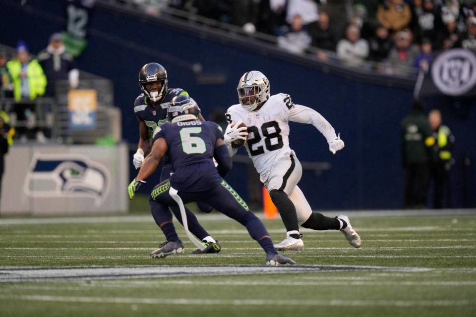 Las Vegas Raiders running back Josh Jacobs runs with the ball during an NFL football game against the Seattle Seahawks, Sunday, Nov. 27, 2022, in Seattle, WA. The Raiders defeated the Seahawks 40-34.