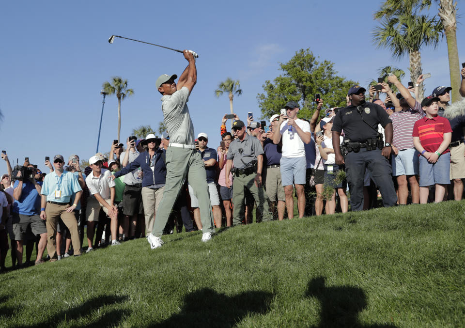 Tiger Woods takes an off-balance swing on the 14th hole during the first round of The Players Championship golf tournament Thursday, March 14, 2019, in Ponte Vedra Beach, Fla. (AP Photo/Lynne Sladky)
