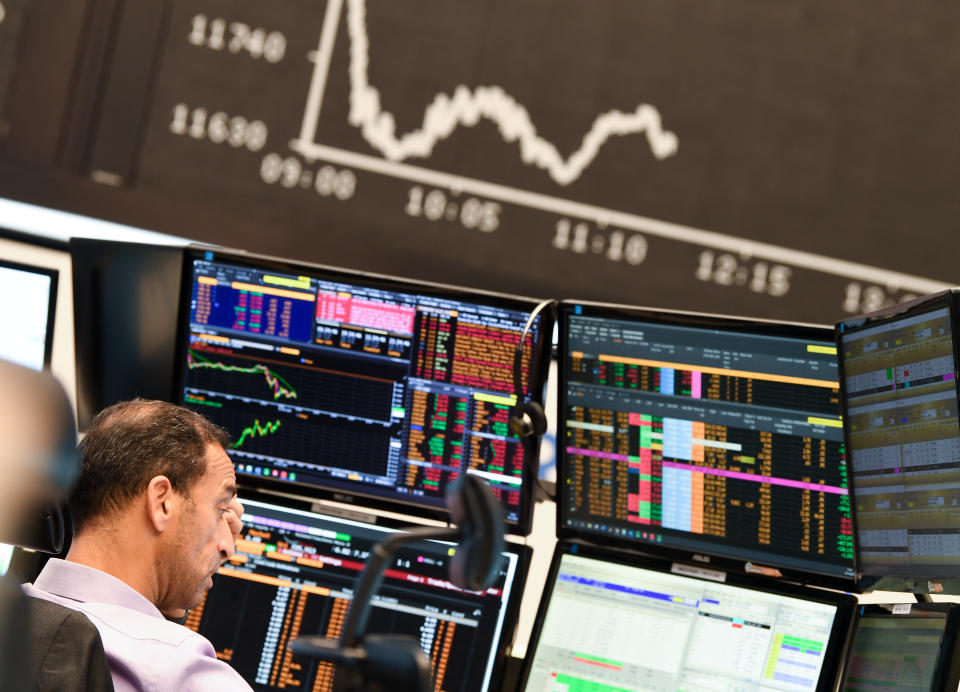 28 October 2020, Hessen, Frankfurt/Main: A stock trader observes his monitors on the floor of the Frankfurt Stock Exchange in front of the board with the falling Dax curve. The worsening corona crisis with rapidly rising infection figures and the threat of a "lockdown" of public life in Germany have put a heavy strain on the German stock market. For the first time since June, the Dax slipped below the 12,000 point mark. It is already more than 13 percent away from the interim high of 13,460 points at the beginning of September. Photo: Arne Dedert/dpa (Photo by Arne Dedert/picture alliance via Getty Images)