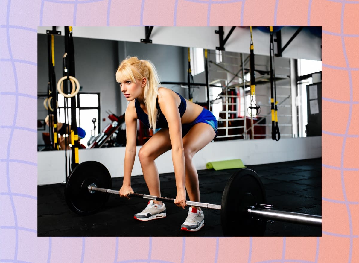 blonde woman doing barbell deadlift at the gym