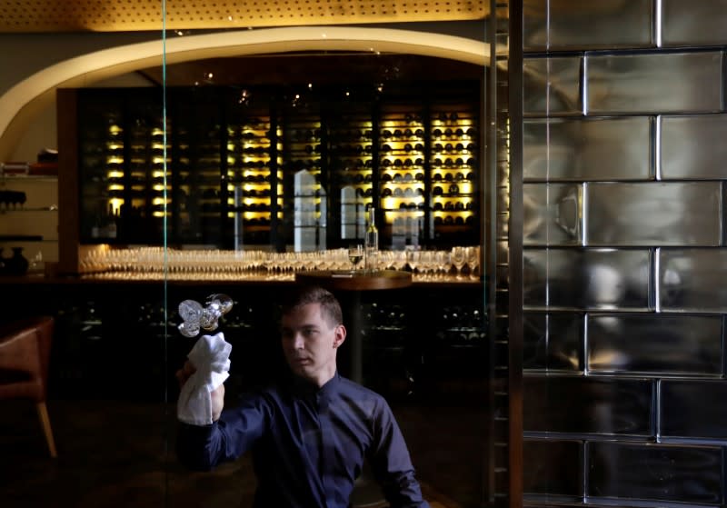 A waiter cleans a door in a restaurant in Prague