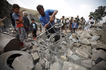 A man retrieves a wheelchair amidst the rubble of a house after it was destroyed by a Saudi-led air strike in Yemen's capital Sanaa, August 11, 2016. REUTERS/Mohamed al-Sayaghi