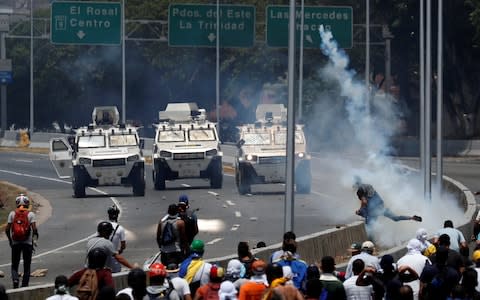 Opposition demonstrators face military vehicles near the Generalisimo Francisco de Miranda Airbase "La Carlota" in Caracas - Credit: &nbsp;CARLOS GARCIA RAWLINS/Reuters