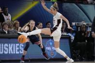UConn's Paige Bueckers passes arpound Stanford's Lexie Hull during the second half of a college basketball game in the semifinal round of the Women's Final Four NCAA tournament Friday, April 1, 2022, in Minneapolis. UConn won 63-58 to advance to the finals. (AP Photo/Charlie Neibergall)
