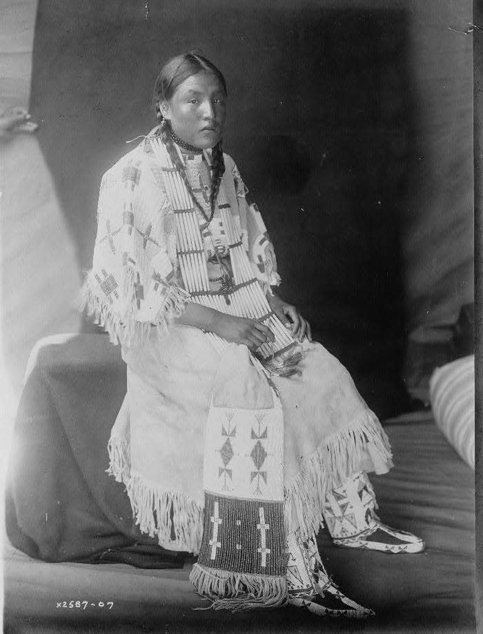 Red Elk Woman, a Sioux girl, full-length portrait, seated, facing right