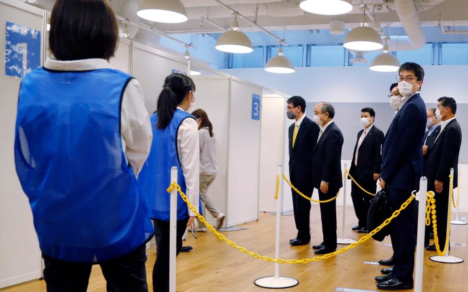 Covid 19 Vaccine Minister Taro Kono, center left, and Masayoshi Son, chief executive of technology company SoftBank Group Corp., center right, visit an inoculation site set up by Japanese technology company SoftBank Group Corp. at a WeWork office Tuesday, June 15, 2021, in Tokyo. - AP