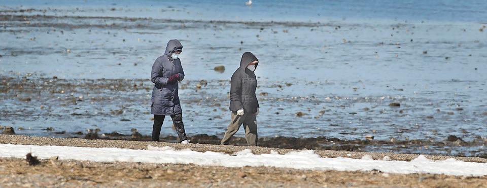 Wollaston Beach walkers wear masks in Quincy.