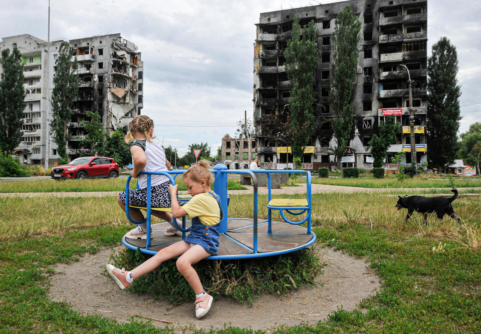 Children play at a playground near a residential area destroyed by Russian shelling in the city of Borodyanka, northwest of the Ukrainian capital Kyiv, on July 7, 2022. - Credit: Sergei Chuzavkov/SOPA Images/LightRocket/Getty Images