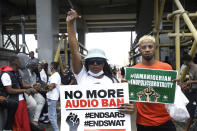 People hold banners as they demonstrate on the street to protest against police brutality in Lagos, Nigeria, Thursday Oct. 15, 2020. Protests against Nigeria's police continued to rock the country for the eighth straight day Thursday as demonstrators marched through the streets of major cities, blocking traffic and disrupting business. (AP Photo/Sunday Alamba)