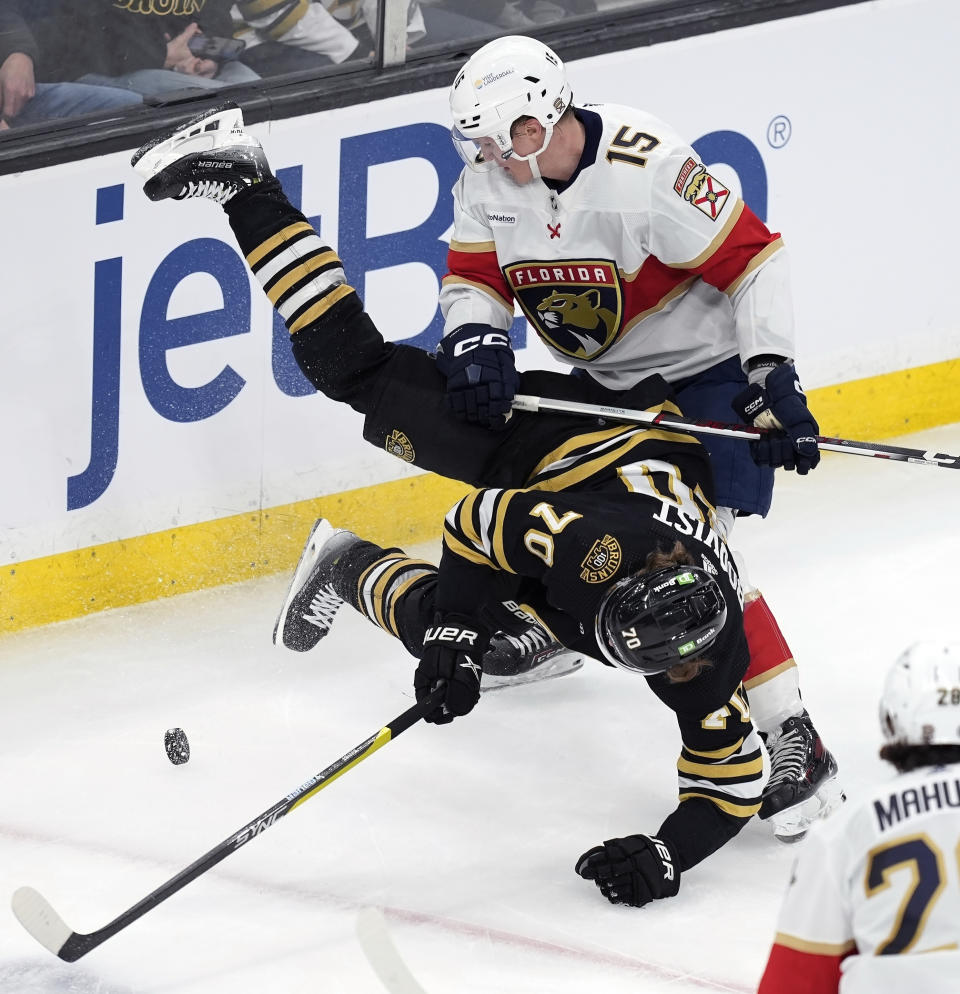 Florida Panthers' Anton Lundell (15) and Boston Bruins' Jesper Boqvist (70) battle for the puck during the second period of an NHL hockey game, Saturday, April 6, 2024, in Boston. (AP Photo/Michael Dwyer)