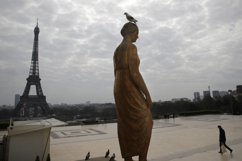 A man walks on the Trocadero square in front of the Eiffel Tower in Paris, Wednesday, March 18, 2020. French President Emmanuel Macron said that for 15 days people will be allowed to leave the place they live only for necessary activities such as shopping for food, going to work or taking a walk. For most people, the new coronavirus causes only mild or moderate symptoms. For some it can cause more severe illness, especially in older adults and people with existing health problems. (AP Photo/Christophe Ena)