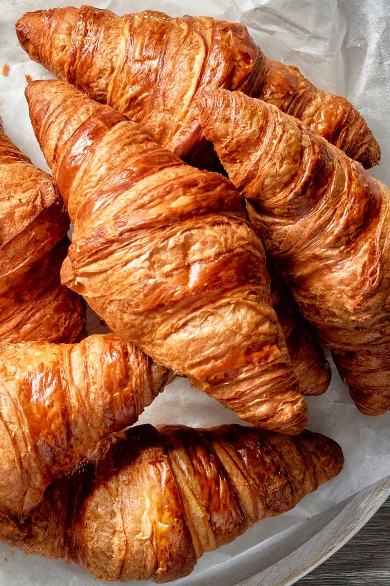 freshly baked croissants on grey wooden table, top view