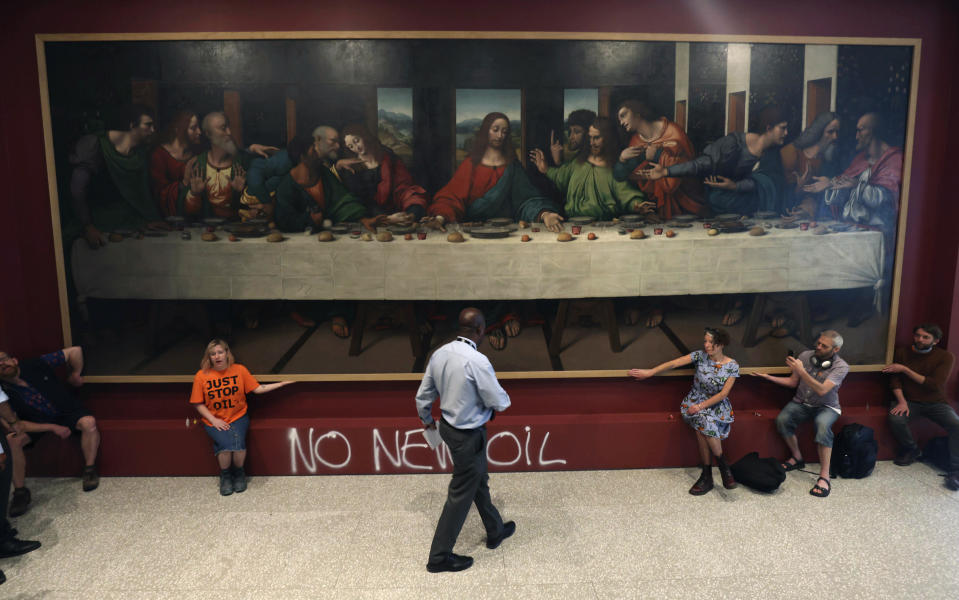 Manifestantes del grupo "Just Stop Oil" pegan sus manos en el marco de una copia de "La última cena" de Leonardo da Vinci, el martes 5 de julio de 2022, en la Real Academia de Londres. (James Manning/PA vía AP)