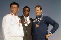 FILE - In this Sept. 6, 1960, file photo, the top three finishers in the decathlon of the 1960 Rome Summer Olympics stand on the podium while wearing their medals at Olympic Stadium in Rome. Rafer Johnson, center, won the gold; Taiwan's Yang Chuan, left, the silver; and Russia's Vasili Kuznetsov the bronze. Rafer Johnson, who won the decathlon at the 1960 Rome Olympics and helped subdue Robert F. Kennedy's assassin in 1968, died Wednesday, Dec. 2, 2020. He was 86. He died at his home in the Sherman Oaks section of Los Angeles, according to family friend Michael Roth.(AP Photo/File)