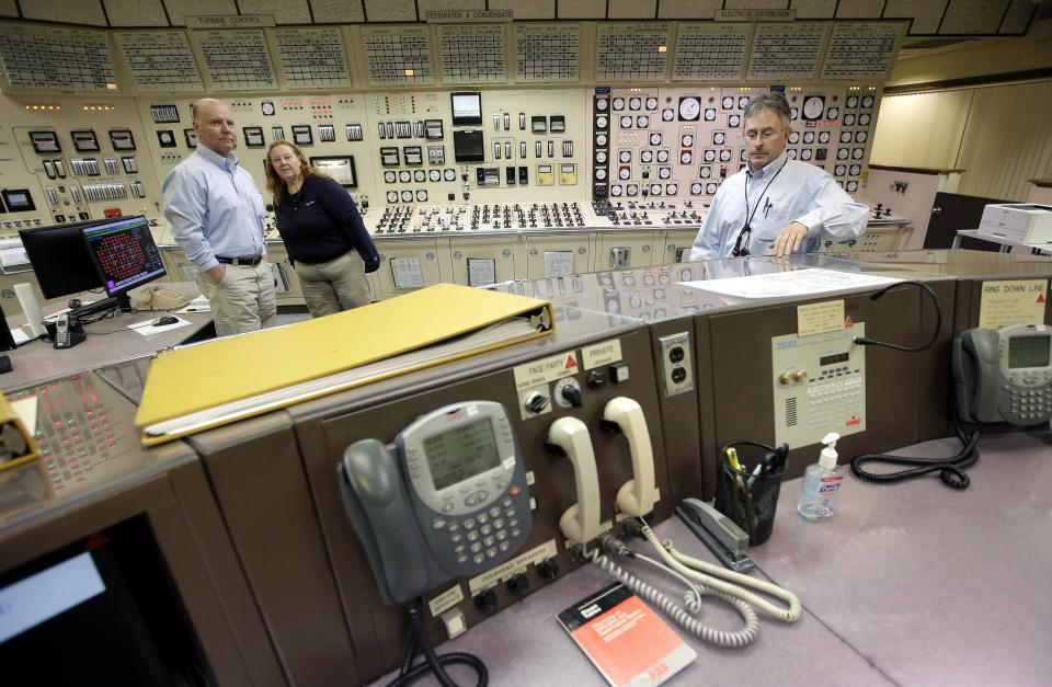 Control Room Supervisor Bob Sheridan, of Duxbury, Mass., left, and Senior Reactor Operator Kelly Connerton, of Middleborough, Mass., center, stand together in the Control Room Simulator moments before a simulated reactor shutdown, Tuesday, May 28, 2019, at a training facility several miles from the Pilgrim Nuclear Power Station, in Plymouth, Mass. The simulated shutdown was performed in front of members of the media ahead of the planned actual shutdown of the aging reactor on Friday, May 31. (AP Photo/Steven Senne)