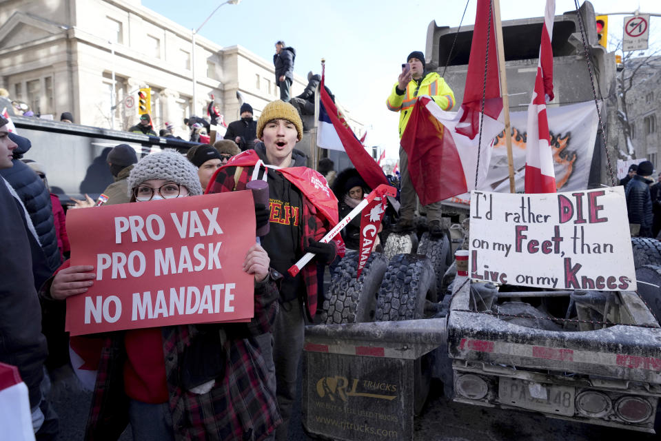 A protester in support of masks and vaccines makes their way through a demonstration in support of a trucker convoy in Ottawa protesting COVID-19 restrictions, at Queen's Park in Toronto, Saturday, Feb. 5, 2022. (Nathan Denette/The Canadian Press via AP)