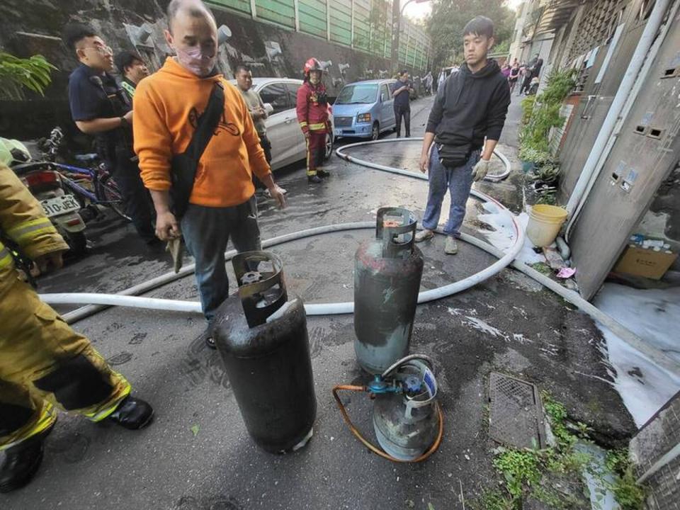 消防人員在火場客廳拉出3支瓦斯桶，解除爆炸危機。（消防局提供）