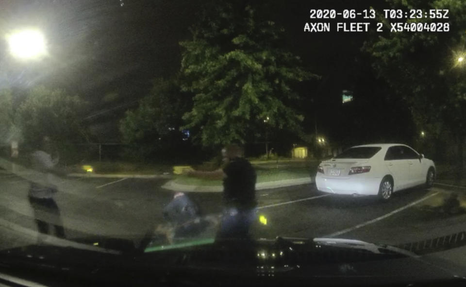 This screen grab taken from dashboard camera video provided by the Atlanta Police Department shows Rayshard Brooks, left, and Officer Garrett Rolfe pointing Tasers at one another, while Officer Devin Brosnan is seen getting up after a struggle among the three men in the parking lot of a Wendy's restaurant, early Saturday, June 13, 2020, in Atlanta. Rolfe has been fired following the fatal shooting of Brooks and Brosnan has been placed on administrative duty. (Atlanta Police Department via AP)