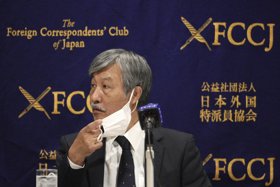 Dr. Naoto Ueyama, chairman of Japan Doctors Union, takes off his face mask during a press conference Thursday, May 27, 2021, in Tokyo. Dr. Ueyama warned Thursday that holding the one-year-delayed Tokyo Olympics in two months could lead to the spread of mutant variants of the coronavirus. (AP Photo/Eugene Hoshiko)
