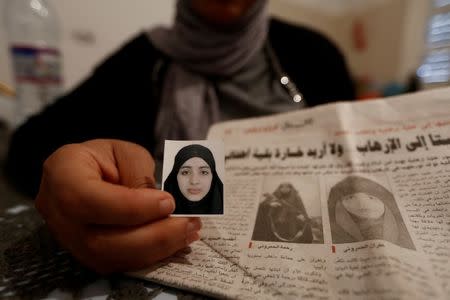 Olfa, 39, shows photographs of her daughters Rahma (R, on the newspaper), wife of Nurdine Chouchan, who was killed during a U.S air strike in Libya, and Ghofran (passport photo and L on newspaper) during an interview with Reuters in Tunis, Tunisia April 14, 2016. REUTERS/Zohra Bensemra