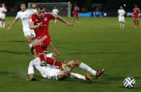 Xherdan Shaqiri of Germany's Bayern Munich trips over Mohamed Oulhaj (bottom) of Morocco's Raja Casablanca during their 2013 FIFA Club World Cup final match at Marrakech stadium December 21, 2013. REUTERS/Youssef Boudlal