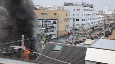 A view of fire and smoke at the site of a train derailment in Yokohama