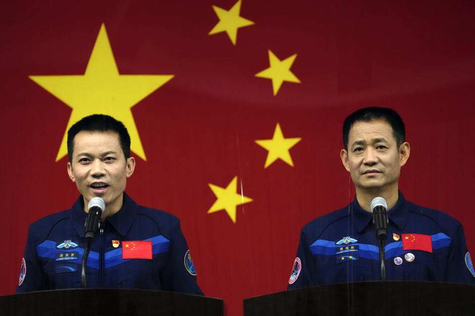 Chinese astronaut Tang Hongbo, left, speaks as fellow astronaut Nie Haisheng listens during a press conference at the Jiuquan Satellite Launch Center ahead of the Shenzhou-12 launch from Jiuquan in northwestern China, Wednesday, June 16, 2021. China plans on Thursday to launch three astronauts onboard the Shenzhou-12 spaceship, who will be the first crew members to live on China's new orbiting space station Tianhe, or Heavenly Harmony from the Jiuquan Satellite Launch Center in northwest China. (AP Photo/Ng Han Guan)