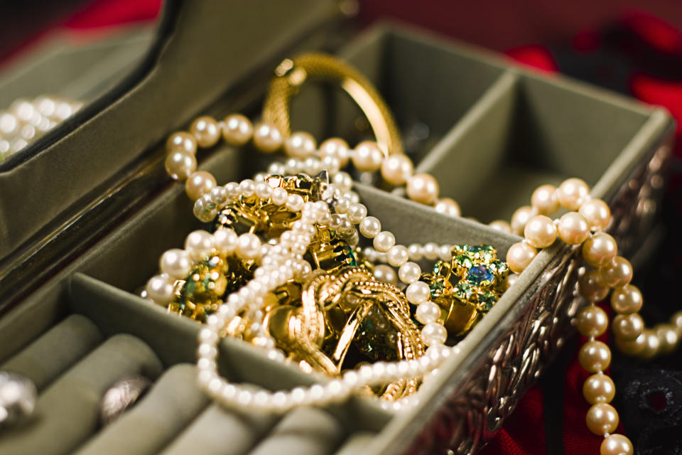 Assorted jewelry with pearls and gemstones in an open box, suggesting wealth or a vintage collection