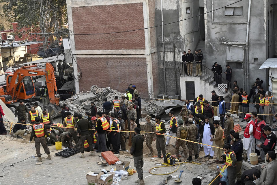 Security officials and rescue workers gather at the site of suicide bombing, in Peshawar, Pakistan, Monday, Jan. 30, 2023. A suicide bomber struck Monday inside a mosque in the northwestern Pakistani city of Peshawar, killing multiple people and wounding scores of worshippers, officials said. (AP Photo/Zubair Khan)