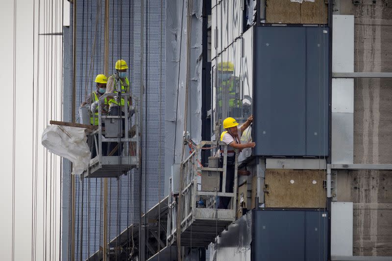 FILE PHOTO: Men work at the construction site of an apartment building in Beijing