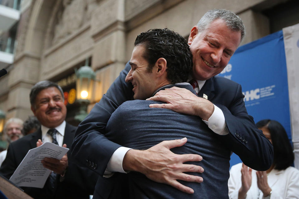 Dr. Craig Spencer, who was diagnosed with Ebola in New York City last month, hugs New York Mayor Bill de Blasio at a news conference at New York's Bellevue Hospital after being declared free of the disease on November 11, 2014.