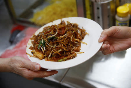 A plate of Char Kuay Teow (fried noodles) is collected by a customer at a hawker centre in Singapore May 21, 2016. Picture taken May 21, 2016. REUTERS/Edgar Su