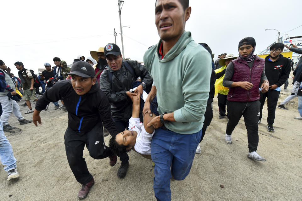 Men carry a fellow anti-government protester who was injured during clashed in Arequipa, Peru, Thursday, Jan. 19, 2023. Protesters are seeking immediate elections, President Dina Boluarte's resignation, the release of ousted President Pedro Castillo and justice for demonstrators killed in clashes with police. (AP Photo/Jose Sotomayor)