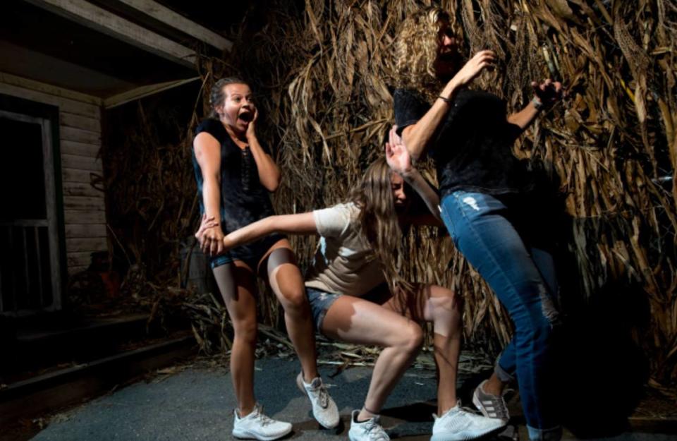 Carowinds visitors in a haunted maze, part of the Scarowinds event.