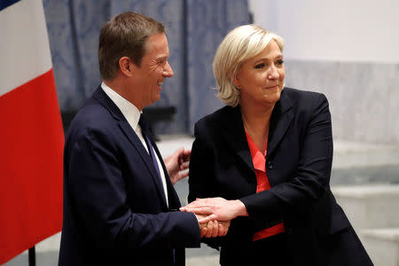 Marine Le Pen (R) French National Front (FN) political party leader and candidate for French 2017 presidential election shakes hands with Debout La France group former candidate Nicolas Dupont-Aignan after a news conference in Paris, France, April 29, 2017. REUTERS/Charles Platiau