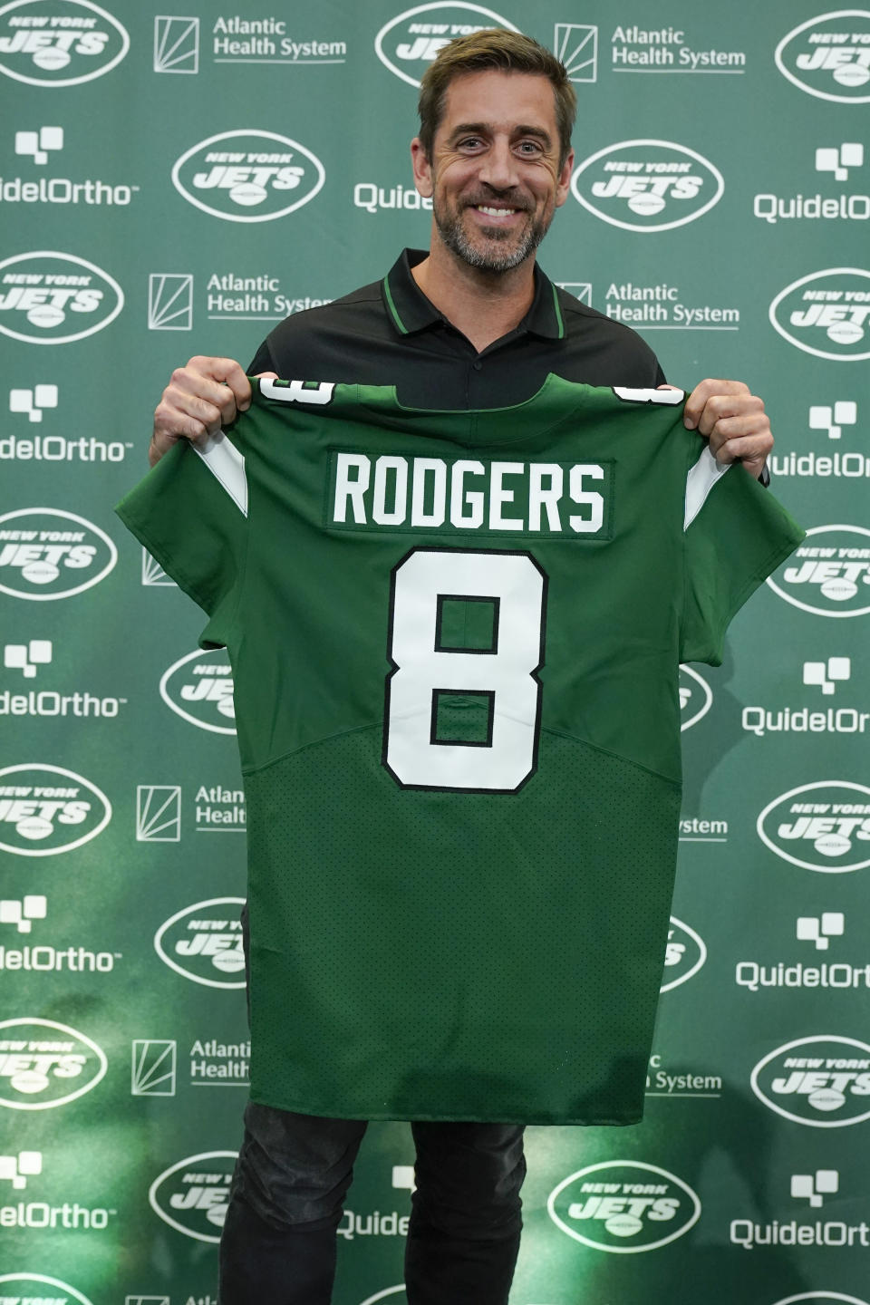 New York Jets' quarterback Aaron Rodgers poses with a jersey after a news conference at the NFL football team's training facility in Florham Park, N.J., Wednesday, April 26, 2023. (AP Photo/Seth Wenig)