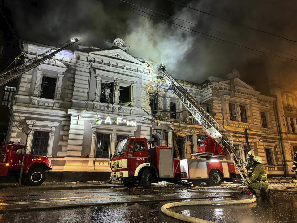 In this photo provided by the Ukrainian Emergency Service, firefighters put out a fire after a Russian missile attack in Kharkiv, Ukraine, Sunday, Dec. 31, 2023. (Ukrainian Emergency Service via AP)