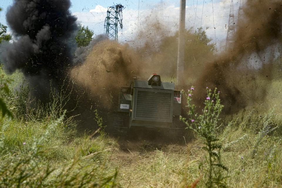 FILE - A Russian military robotic vehicle detonates a land mine on a mine clearing mission along the high voltage line in Mariupol, on the territory which is under the Government of the Donetsk People's Republic control, eastern Ukraine, on July 13, 2022. Even as the Russian war machine crawls across Ukraine’s east, trying to achieve the Kremlin’s goal of securing a full control over the country’s industrial heartland of the Donbas, the Ukrainian forces are scaling up attacks to reclaim territory in the south. (AP Photo, File)