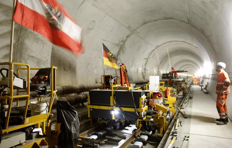 An Austrian and a German national flag fly on mobile machinery during the installation of the railway tracks in the NEAT Gotthard Base tunnel near Erstfeld May 7, 2012. Crossing the Alps, the world's longest train tunnel should become operational at the end of 2016. The project consists of two parallel single track tunnels, each of a length of 57 km (35 miles)