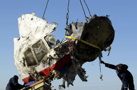 Local workers transport a piece of the Malaysia Airlines flight MH17 wreckage at the site of the plane crash near the village of Hrabove (Grabovo) in Donetsk region, eastern Ukraine November 20, 2014. REUTERS/Antonio Bronic